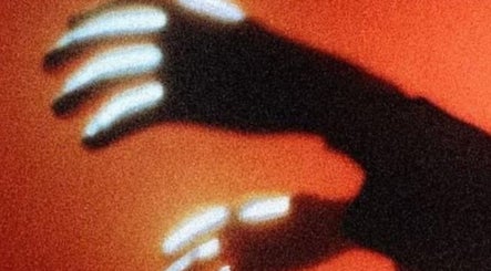 Ombra di mani su sfondo arancione a Nostress, Napoli, Campania, IT. Arte e benessere unici.