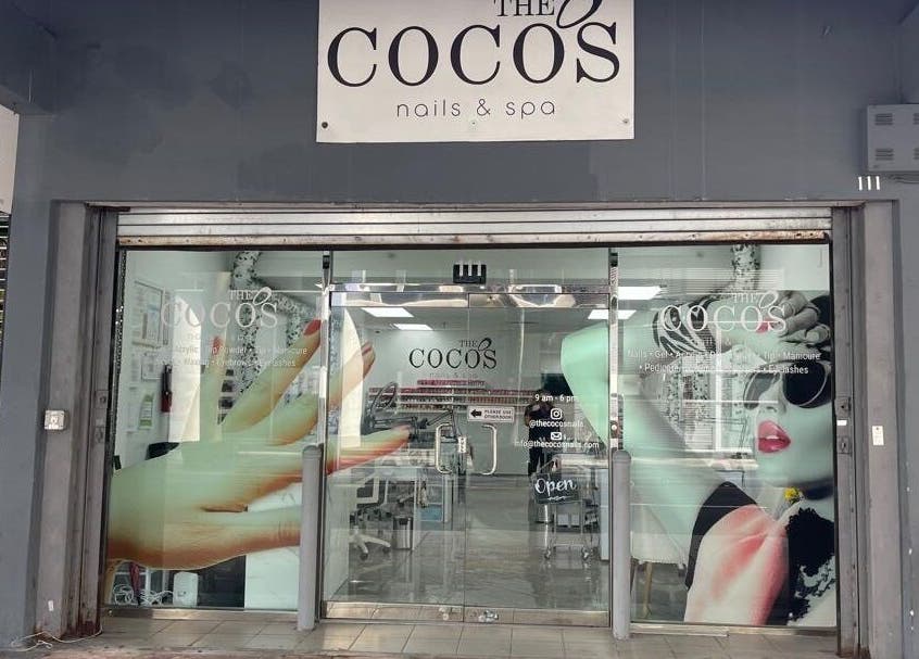 Front entrance of The Coco's Nail & Spa in Miami, Florida, US showcasing chic window art and inviting interiors.