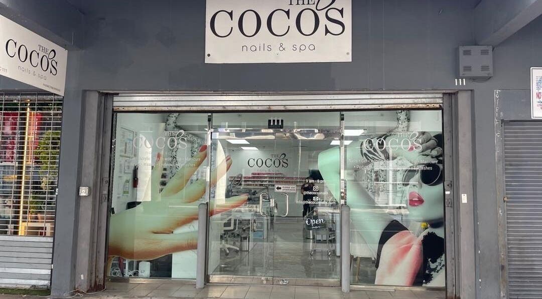Front entrance of The Coco's Nail & Spa in Miami, Florida, US showcasing chic window art and inviting interiors.