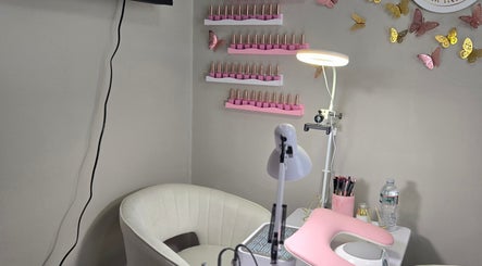 Espacio de manicura en Chismesito, Malden, Massachusetts, US, decorado con mariposas y tonos pastel.