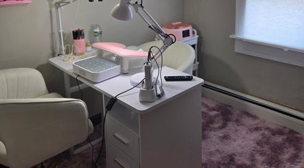 Espacio de manicura en Chismesito, Malden, Massachusetts, US con silla blanca y lámpara moderna.