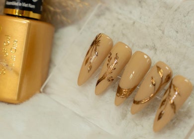 Elegant almond nails with gold leaf design at Lullea Nails Shop, Toronto, Ontario, CA.
