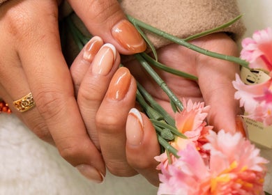 Elegant manicured hands with peach nails and flowers at Lullea Nails Shop, Toronto, Ontario, CA.