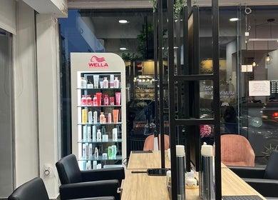 Ένα μοντέρνο σαλόνι στο VIP Beauty Box, Αθήνα, GR, με καρέκλες και προϊόντα ομορφιάς.