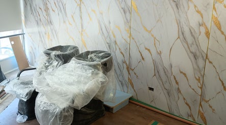 Interior de Marsella Studio con sillas cubiertas y fondo de mármol en Buenos Aires, Ciudad Autónoma De Buenos Aires, AR.