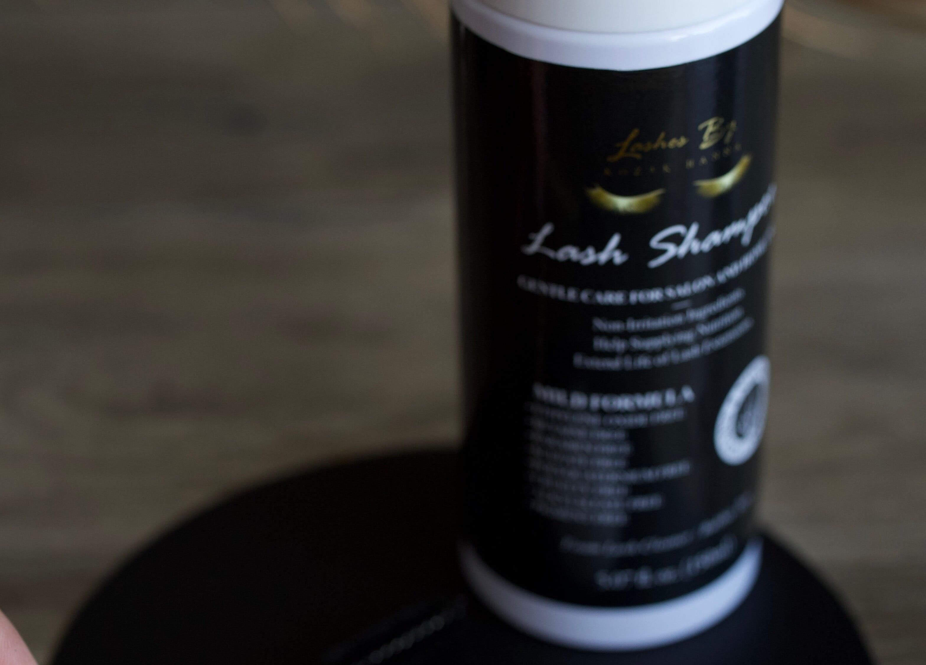 Lash shampoo product at UNOVA lashes by HK, Hallandale Beach, Florida, US, displayed on wooden surface.