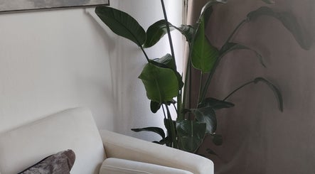 Salon lumineux et moderne chez ART institut, Genève, Genève, CH avec plante verte et fauteuil blanc.