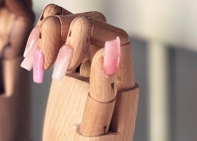 Houten hand met roze kunstnagels bij House of Beauty by Lina in Rotterdam, Zuid-Holland, NL.