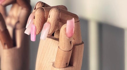 Houten hand met roze kunstnagels bij House of Beauty by Lina in Rotterdam, Zuid-Holland, NL.