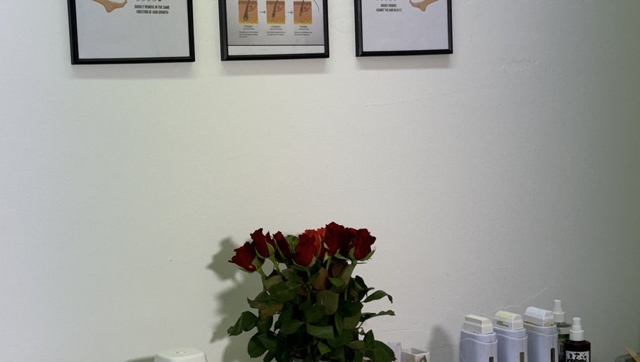 Aesthetic wall art and red roses at Sweet Epil Beauty, London, GB, creating a calming ambiance in the treatment room.