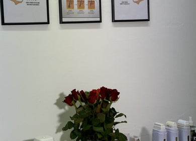 Aesthetic wall art and red roses at Sweet Epil Beauty, London, GB, creating a calming ambiance in the treatment room.