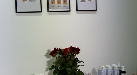 Aesthetic wall art and red roses at Sweet Epil Beauty, London, GB, creating a calming ambiance in the treatment room.