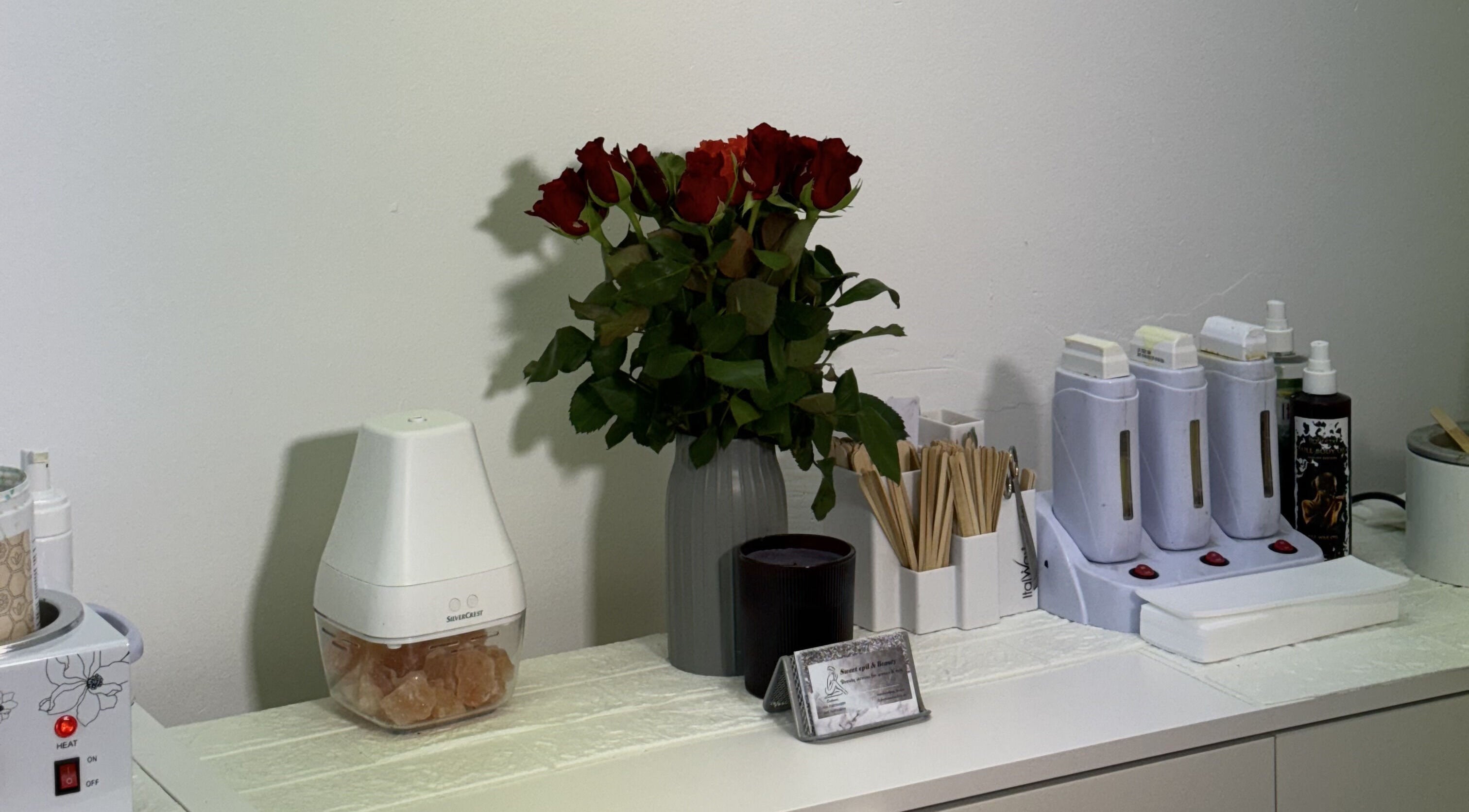 Elegant spa setup at Sweet Epil Beauty, London, England, GB with roses and professional spa tools.