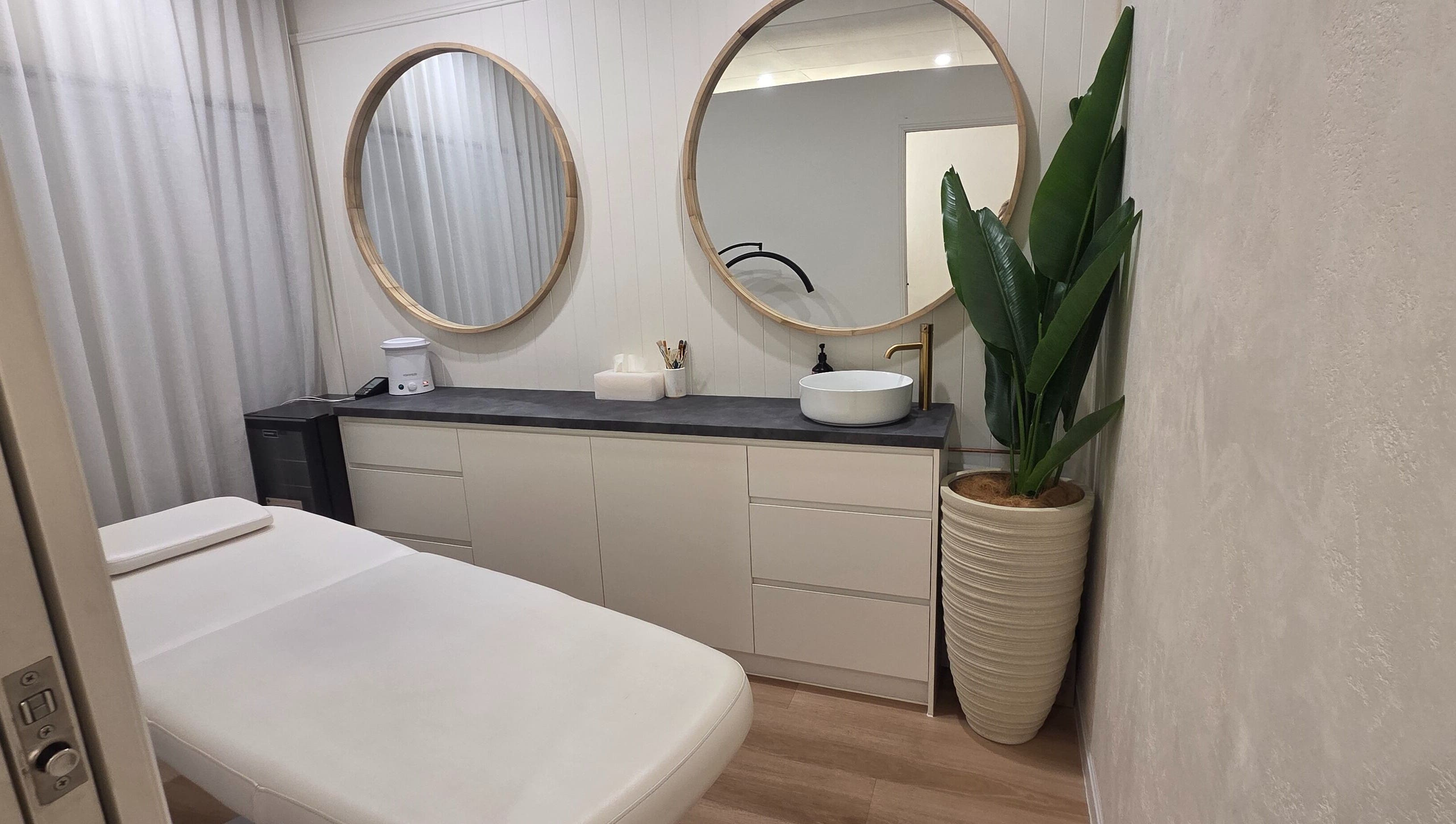 Relaxing treatment room at Ease & Elevate, Burleigh Heads, QLD, AU, featuring modern decor and lush greenery.