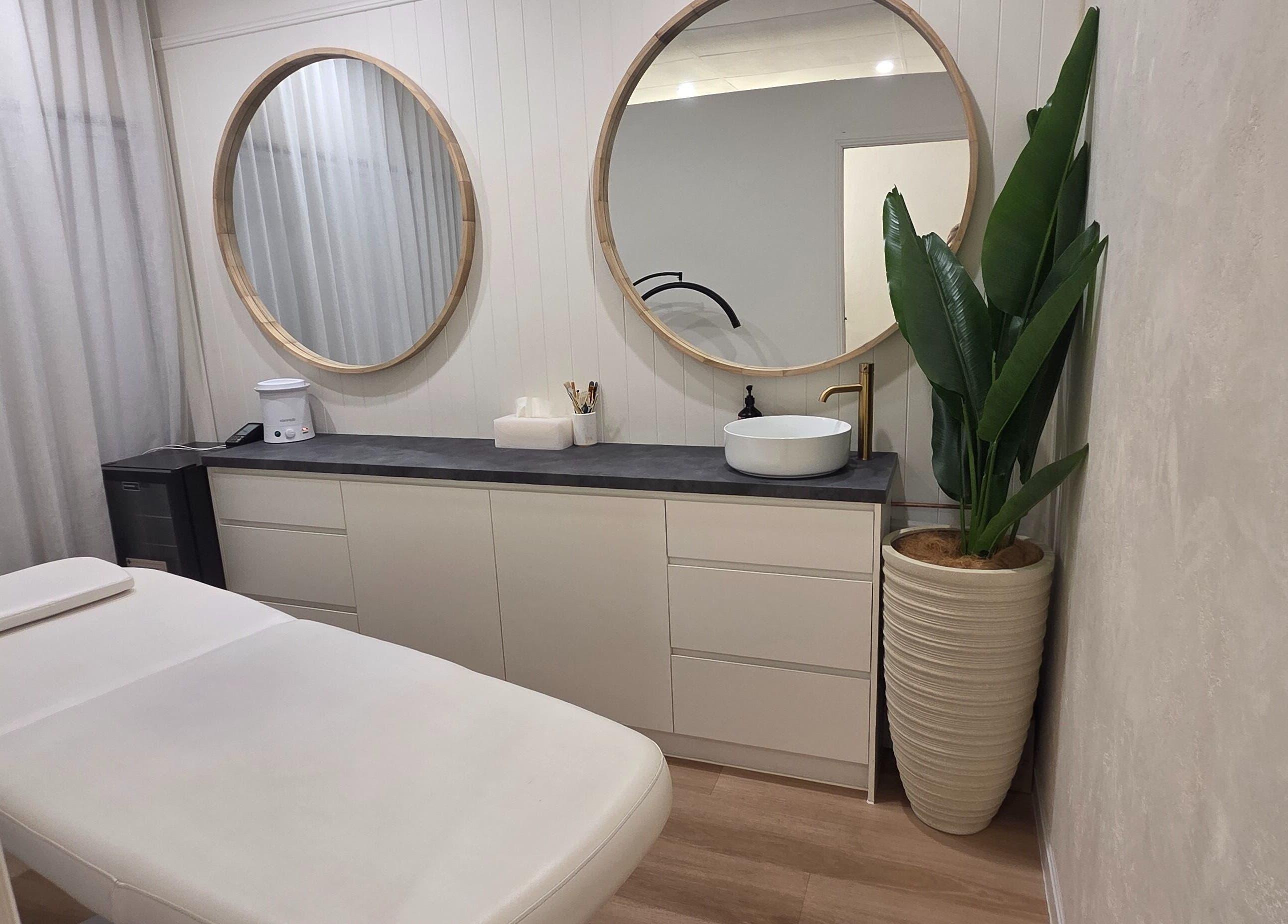 Relaxing treatment room at Ease & Elevate, Burleigh Heads, QLD, AU, featuring modern decor and lush greenery.