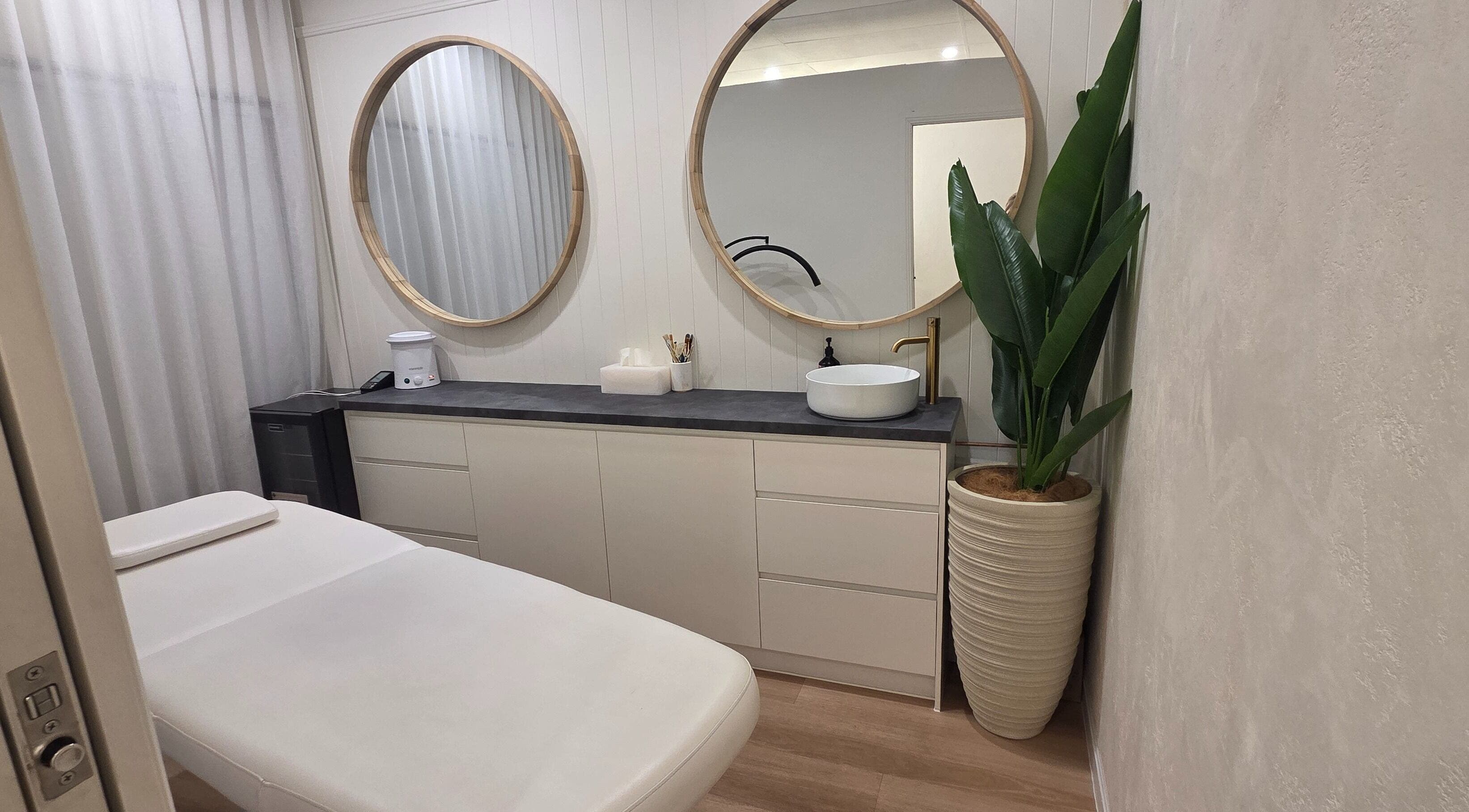 Relaxing treatment room at Ease & Elevate, Burleigh Heads, QLD, AU, featuring modern decor and lush greenery.
