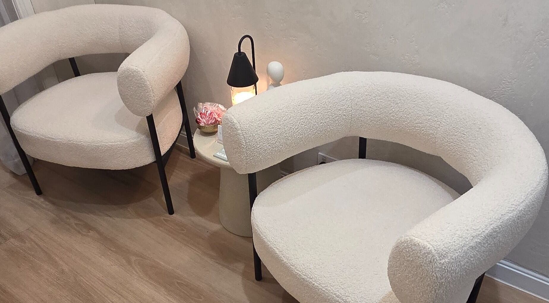 Two elegant cream chairs and a lamp in a serene setting at Ease & Elevate, Burleigh Heads, QLD, AU.