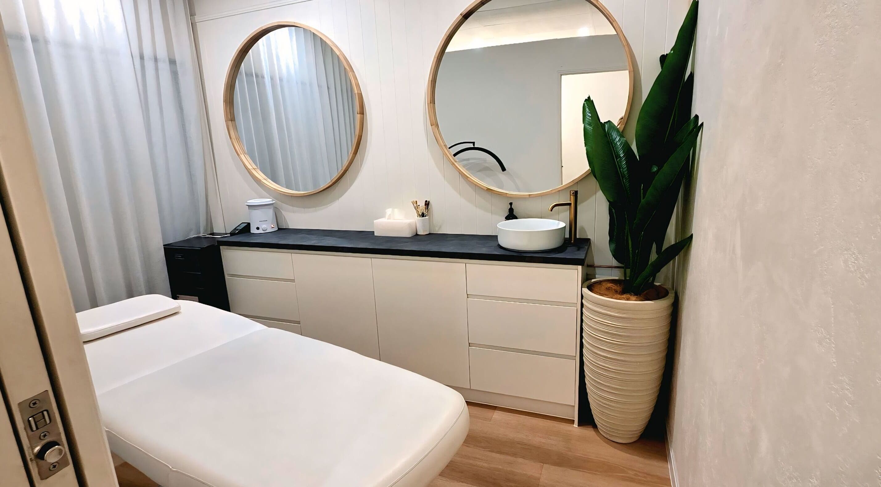 Elegant treatment room at Ease & Elevate, Burleigh Heads, QLD, AU with mirrors and plant decor.