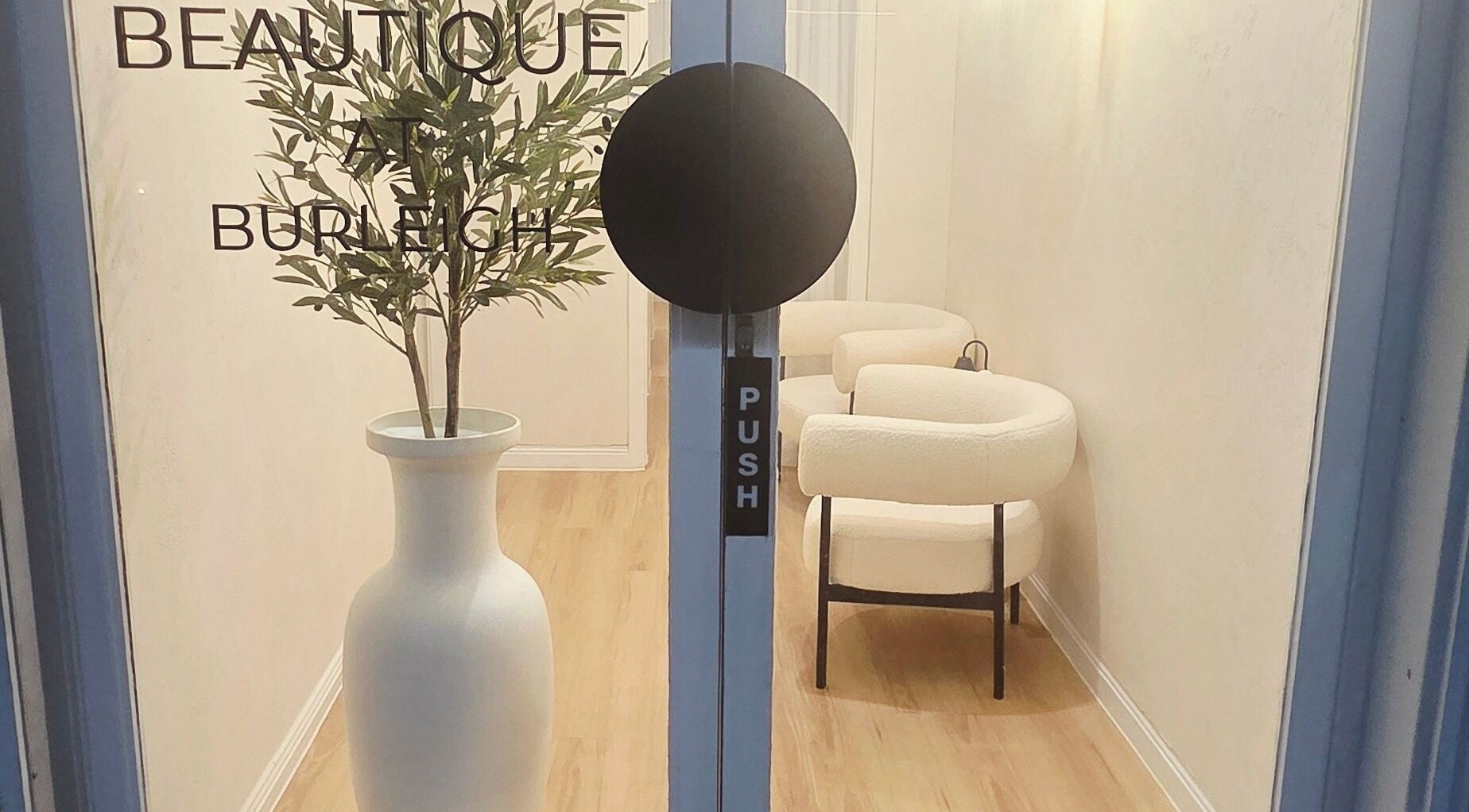 Entrance of Ease & Elevate, Burleigh Heads, QLD, AU, featuring elegant decor with a potted plant and chairs.