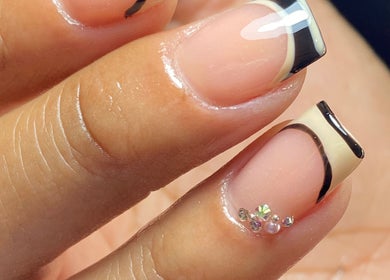 Stylish nail design at Carmen Sanchez Nail Art in Atlixco, Puebla, MX showcasing black French tips and gems.