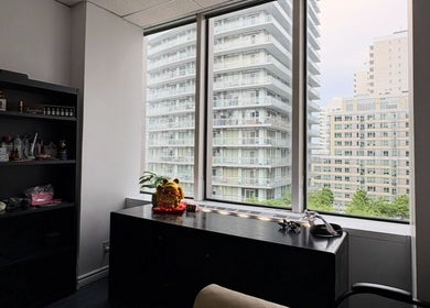 Modern office at Beca’s Beauty Spectrum in Toronto, Ontario, CA with cityscape view through large windows.
