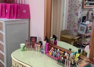 Glamorous makeup station at Poppy’s Make Up & Beauty Bar in Redditch, England, GB featuring cosmetics and mirror.