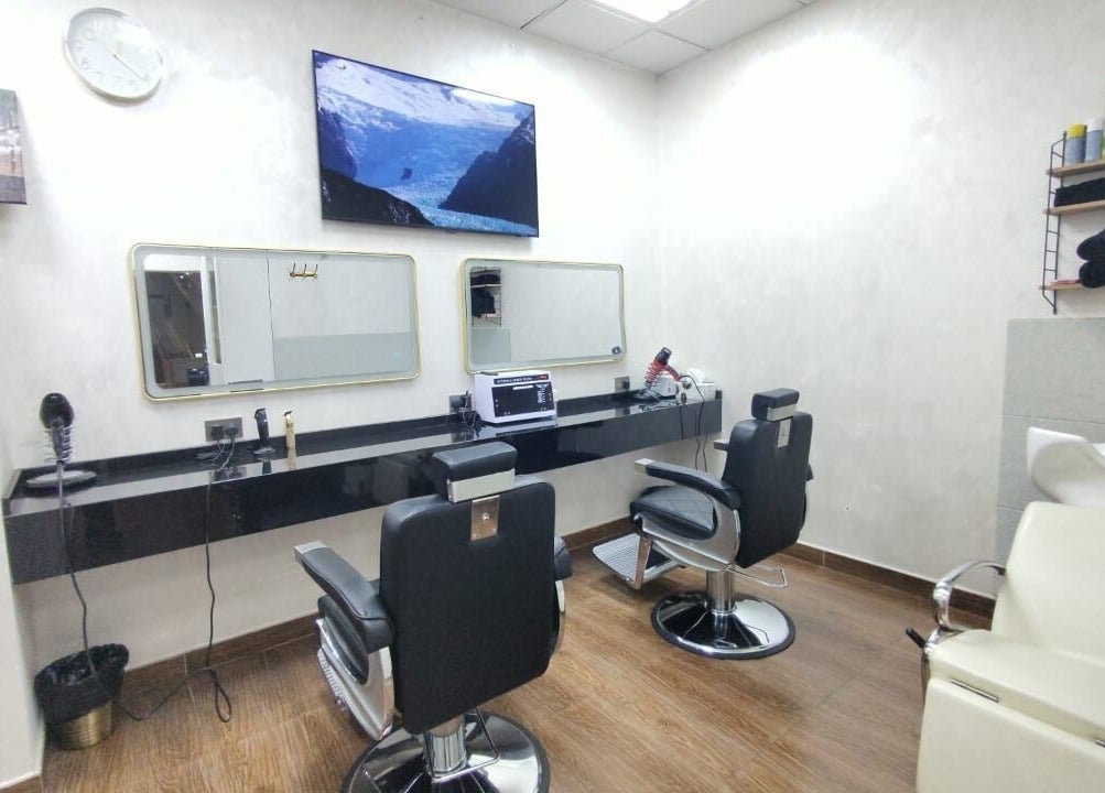Modern salon interior at 24 minutes, Abu Dhabi, AE featuring sleek black chairs and mirrors.