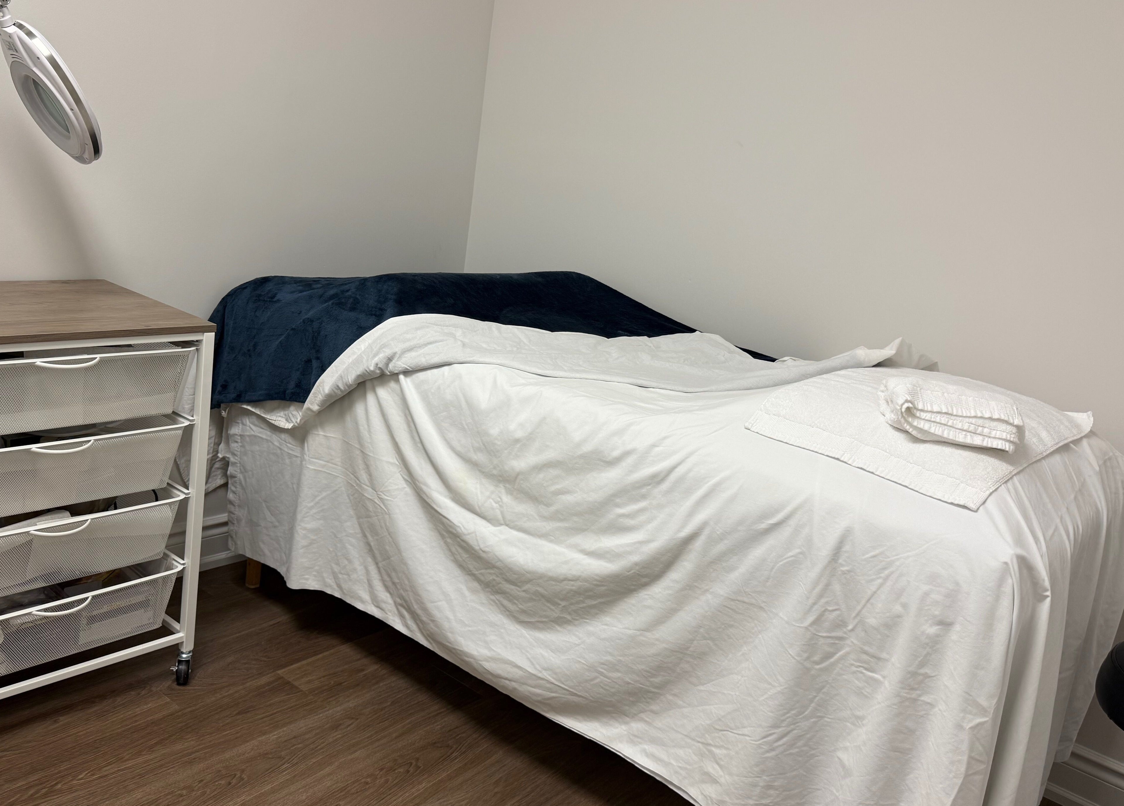 Tranquil massage room at Glamify Wellness Spa in Vaughan, Ontario, CA with bed and a cozy setting.