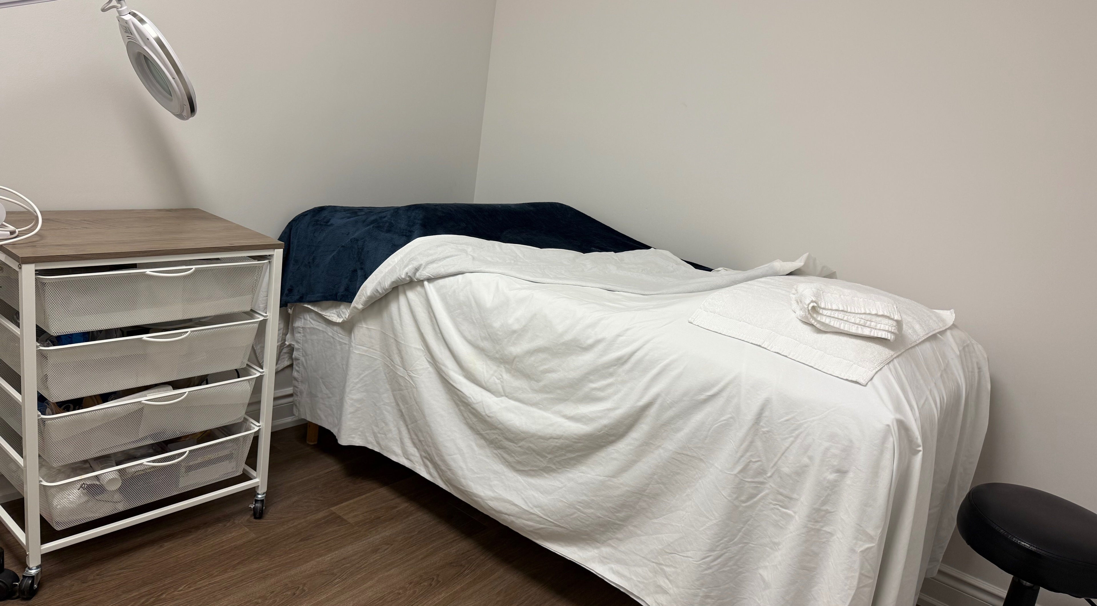 Tranquil massage room at Glamify Wellness Spa in Vaughan, Ontario, CA with bed and a cozy setting.