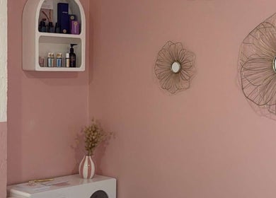Coin déco de Maison Maréa à Bourg-de-péage, Auvergne-rhône-alpes, FR avec mur rose et étagère d'articles de beauté.