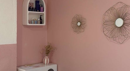 Coin déco de Maison Maréa à Bourg-de-péage, Auvergne-rhône-alpes, FR avec mur rose et étagère d'articles de beauté.