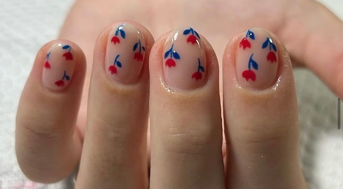 Elegant nail art with red and blue flowers at Luciana camiña, 9 De Julio, Provincia De Buenos Aires, AR.