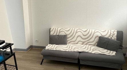 Salon confortable chez jm'nails55, Bar-le-Duc, Grand Est, FR avec canapé élégant et couverture.