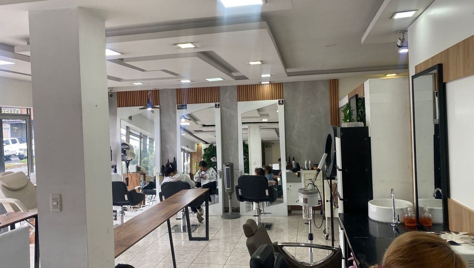 Interior moderno de Blondin Studio en Quito, Pichincha, EC, con estaciones de belleza iluminadas.