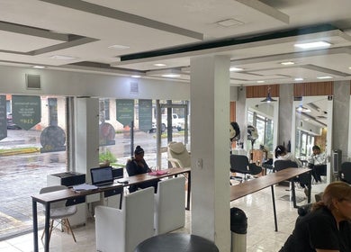 Interiores elegantes de Blondin Studio en Quito, Pichincha, EC, destacando áreas de peinado y relajación.