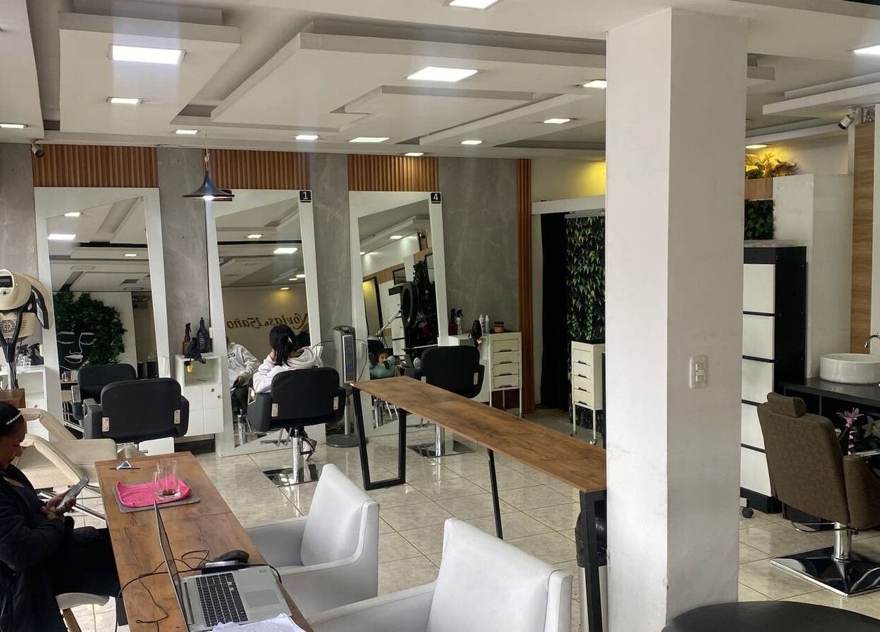 Interior moderno de Blondin Studio en Quito, Pichincha, EC con estaciones de belleza iluminadas.