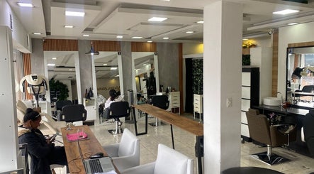 Interior moderno de Blondin Studio en Quito, Pichincha, EC con estaciones de belleza iluminadas.