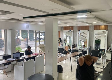 Interior moderno de Blondin Studio en Quito, Pichincha, EC con sillas de salón, espejos y estaciones de trabajo.