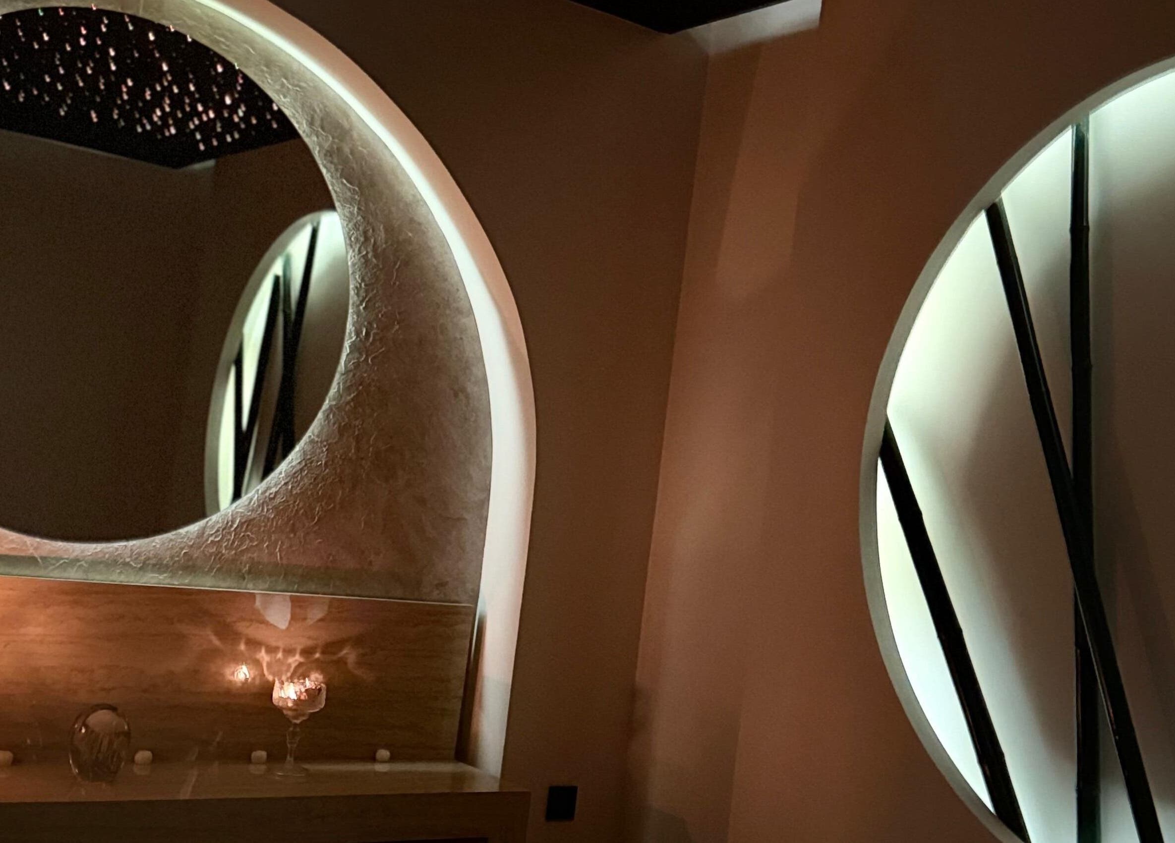 جو هادئ بإضاءة هادئة عند مرآة مستديرة في Touche Salon & Spa الرياض، السعودية.