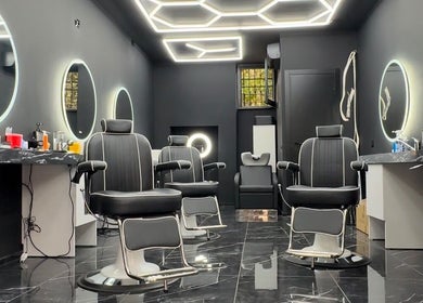 Stylish interior of Euro Cut Barber in Roma, Lazio, IT with modern barber chairs and illuminated mirrors.