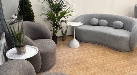 Elegant waiting area at Vera Beauty & Aesthetic, Brighton And Hove, with modern grey seating and lush greenery.
