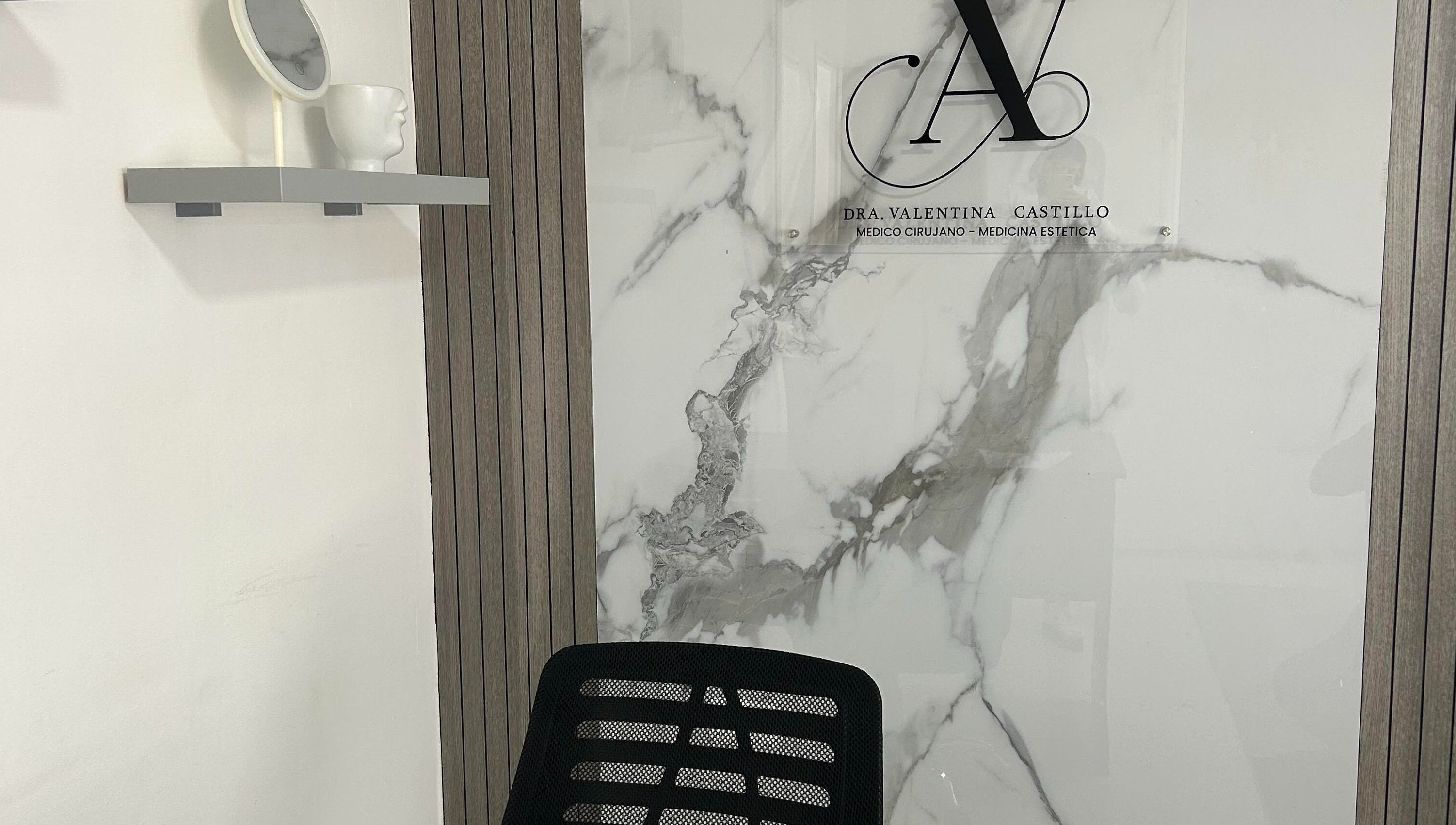 Decoración elegante en Dra. Valentina Castillo, Valencia, Carabobo, VE, con pared de mármol y espejo moderno.