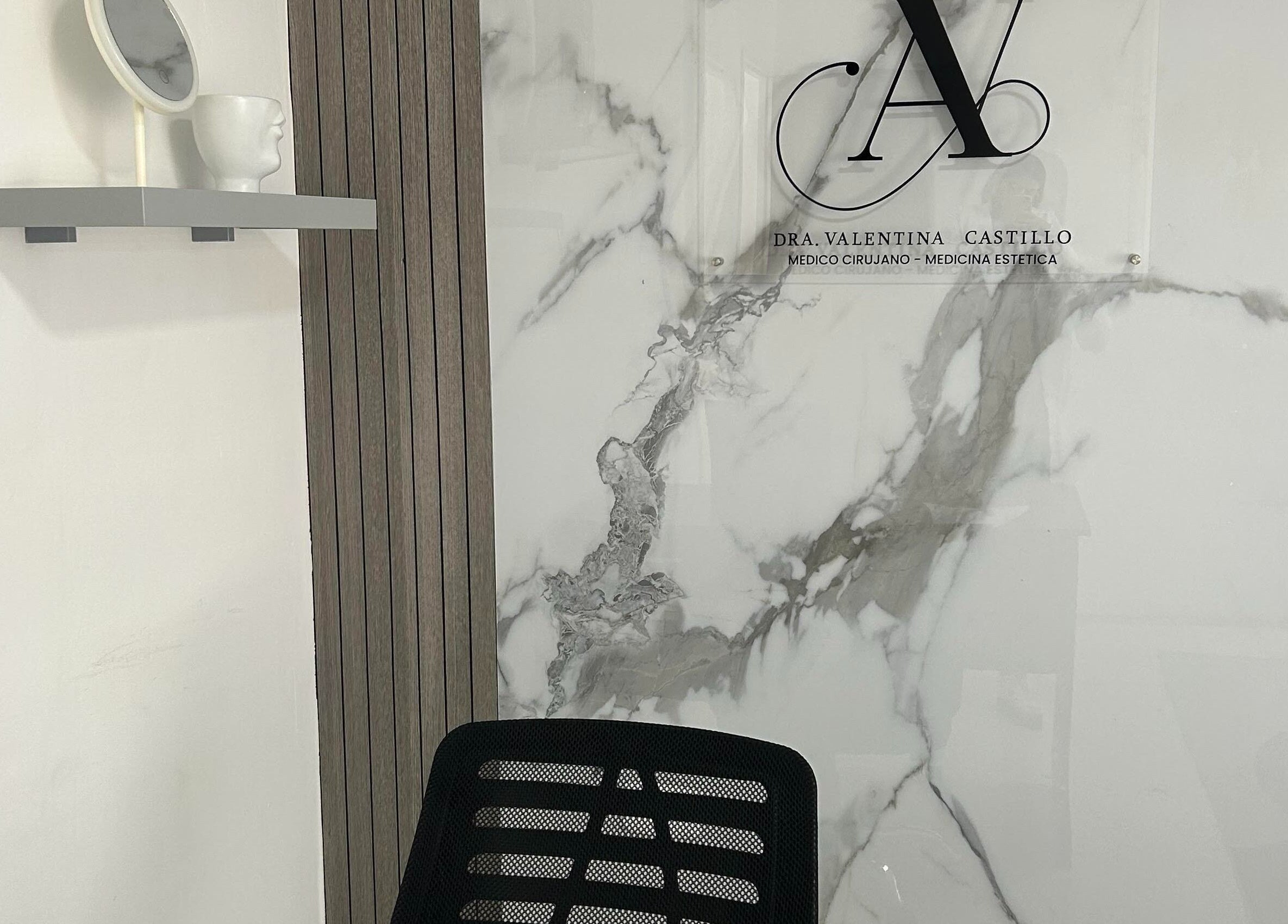 Decoración elegante en Dra. Valentina Castillo, Valencia, Carabobo, VE, con pared de mármol y espejo moderno.