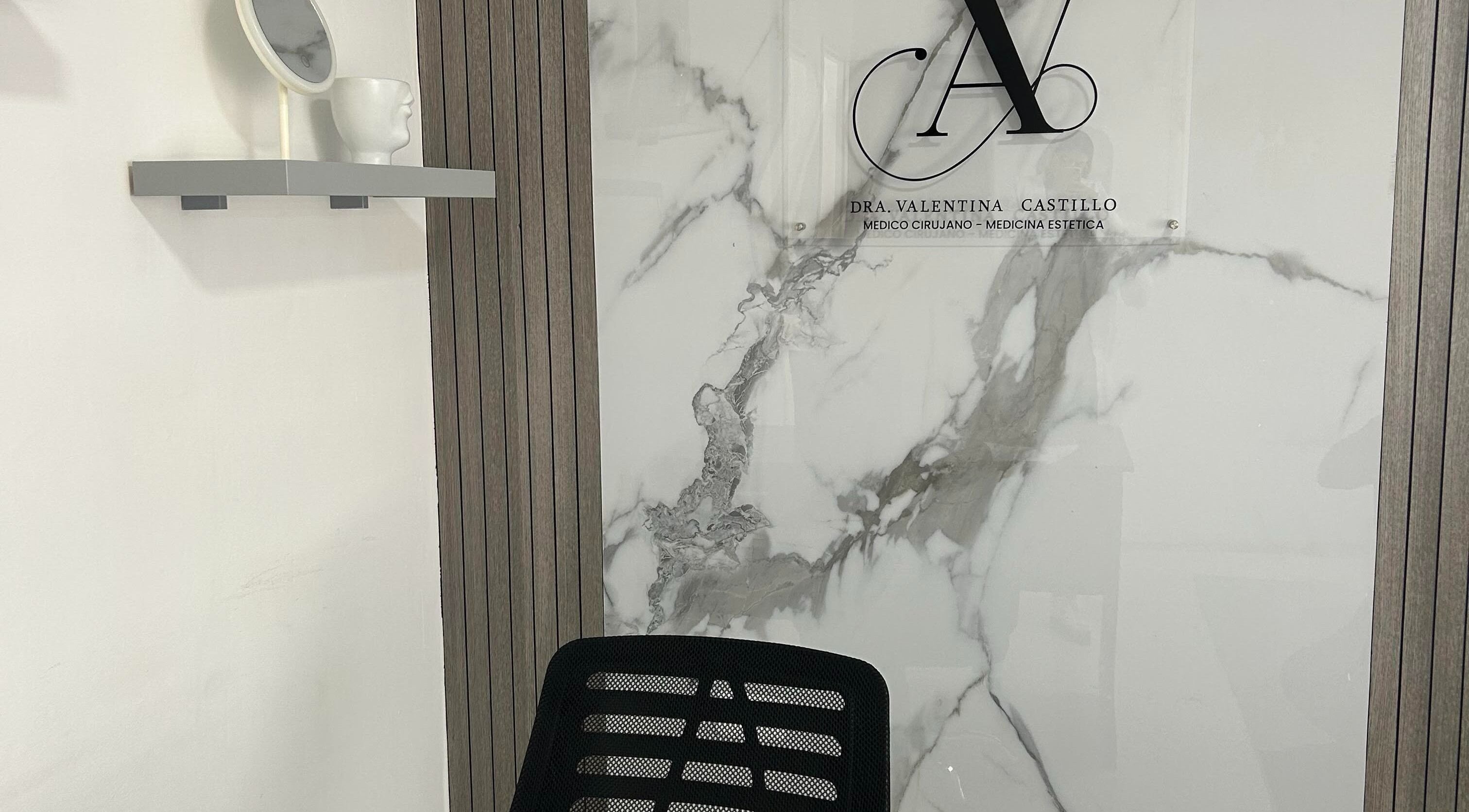 Decoración elegante en Dra. Valentina Castillo, Valencia, Carabobo, VE, con pared de mármol y espejo moderno.