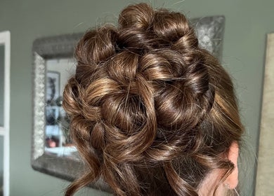 Intricate updo hairstyle at Bylucydomeneghetti, Durham, England, GB, showcasing expert braiding technique.