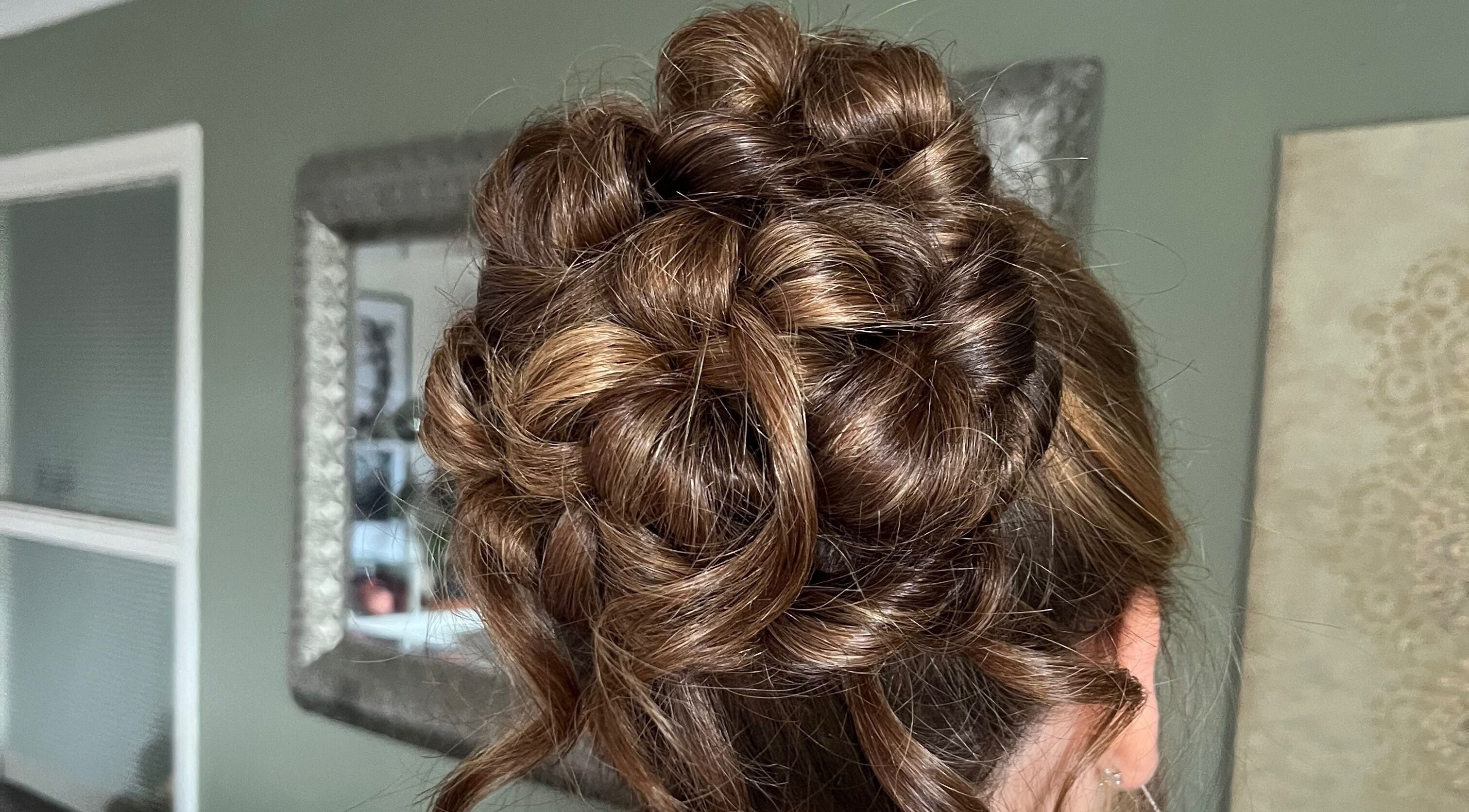 Detailed bridal updo hairstyle at Bylucydomeneghetti in Durham, England, GB, showcasing intricate braiding.