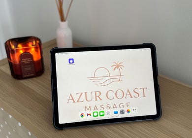 Tablet displaying Azur Coast Massage logo by candlelight at O'sullivan Beach, South Australia, AU.