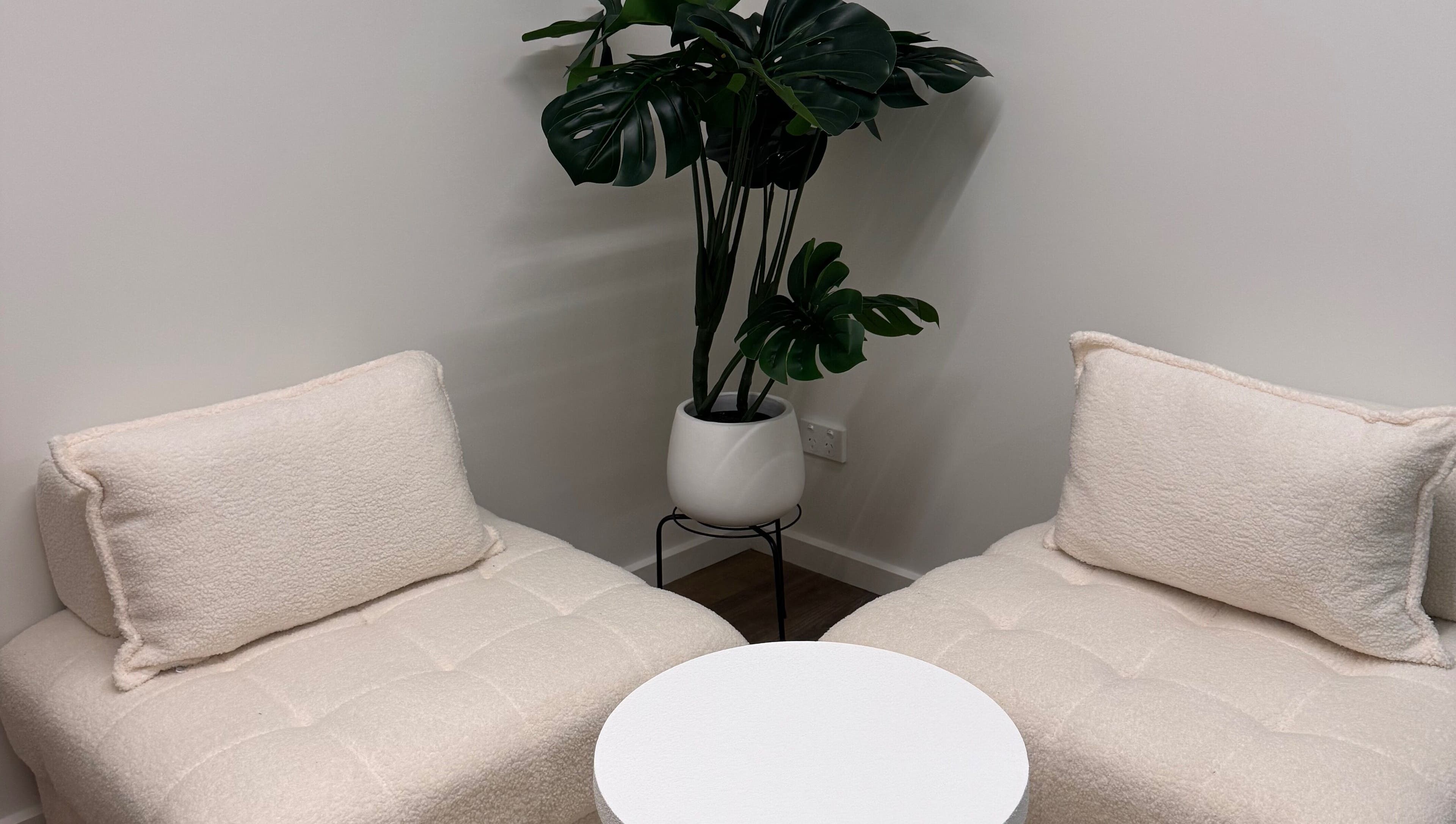 Inviting seating with plush chairs and a chic plant at BRNZD, Hawker, Australian Capital Territory, AU.