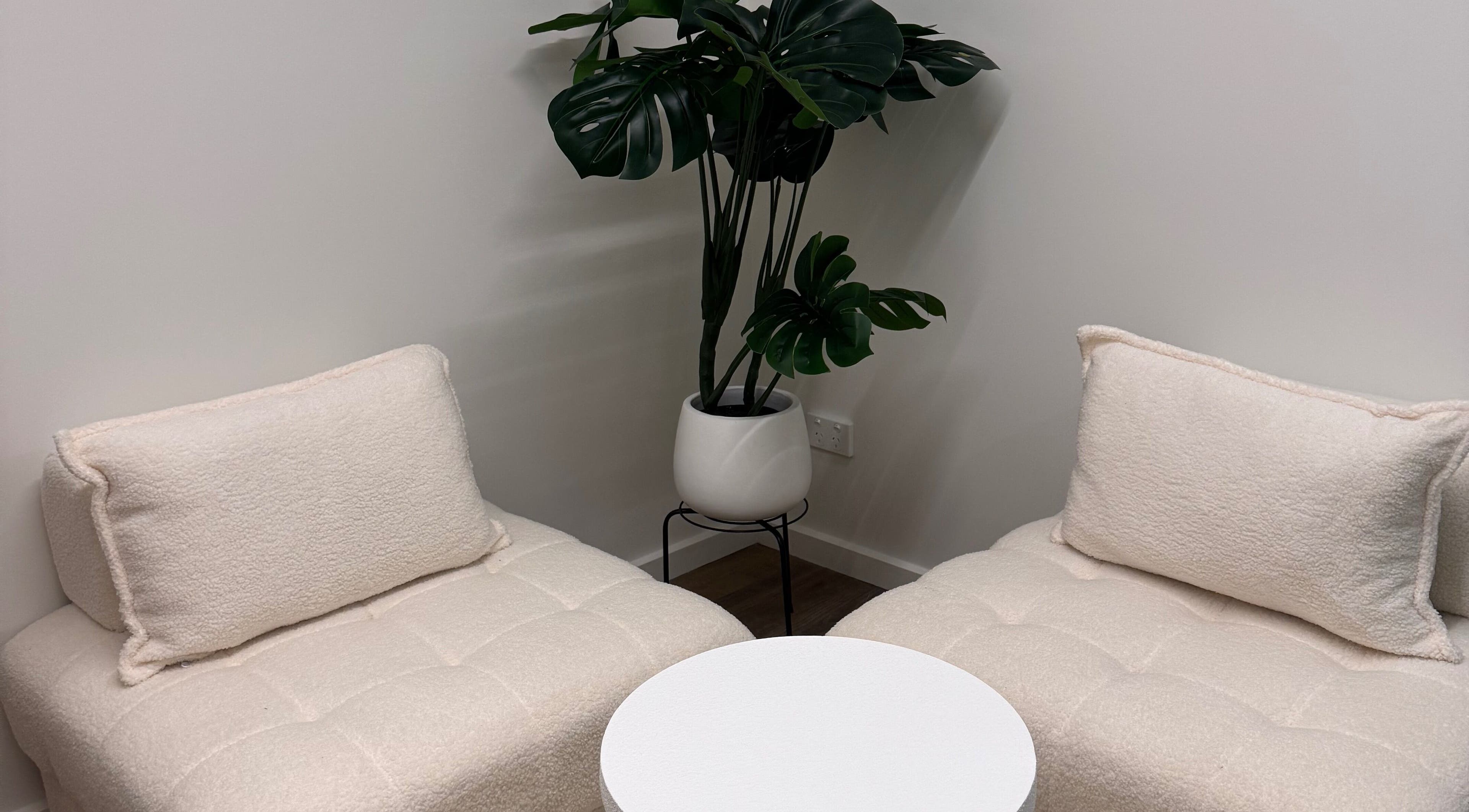 Inviting seating with plush chairs and a chic plant at BRNZD, Hawker, Australian Capital Territory, AU.