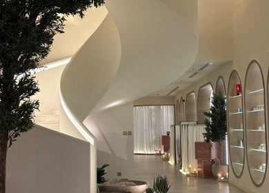 تصميم داخلي فاخر في Myomi Spa، الرياض، يشمل درج حلزوني وأضواء دافئة.